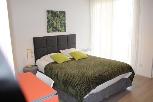 尼奥尔尼奥尔城市小屋公寓式酒店的一间卧室配有一张大床和两个绿色枕头