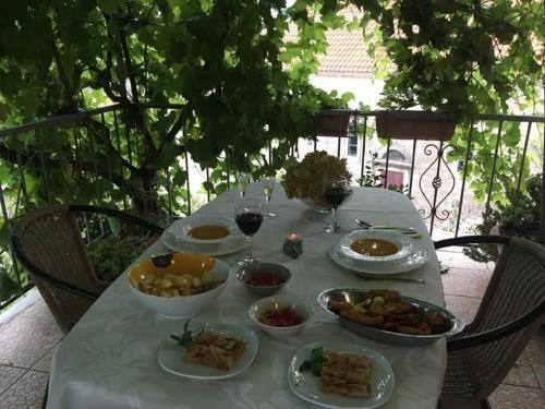 拉斯托伏Apartment Brezak的餐桌,带食物盘和酒杯