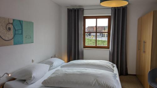 诺尔德海姆Ferienwohnungen Familie Neubert的卧室设有两张床,带窗户