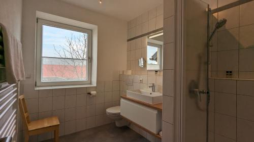 诺尔德海姆Ferienwohnungen Familie Neubert的一间带水槽和卫生间的浴室以及窗户。