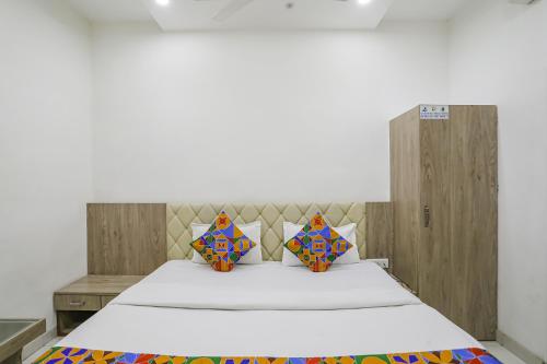 奥兰加巴德FabHotel Angeethi的一间卧室配有一张大床和木制床头板