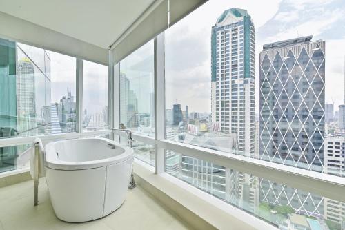 曼谷曼谷易思廷大酒店沙吞的带浴缸的浴室和大窗户