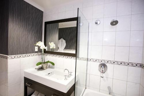 北帕默斯顿Distinction Coachman Hotel, Palmerston North的白色的浴室设有水槽和镜子