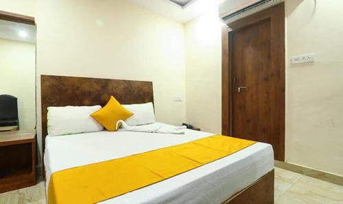 瓜廖尔FabHotel Rama Inn I的一间卧室配有一张带黄色和白色枕头的大床
