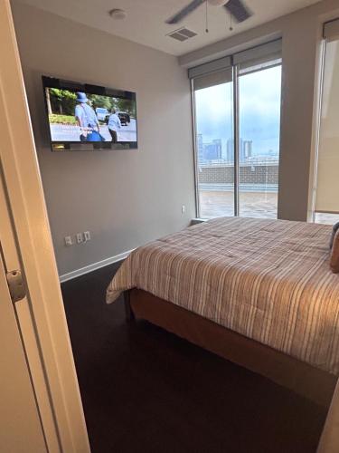 达拉斯On The Go Stays(Penthouse)的卧室配有一张床,墙上配有电视。