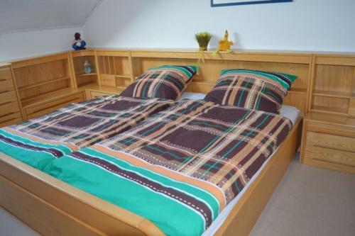 布里隆Almer Ferienwohnung的一间卧室配有一张带两个枕头的木床