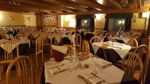帕苏德尔托纳莱蓝天酒店的用餐室配有桌椅和白色的桌子床单