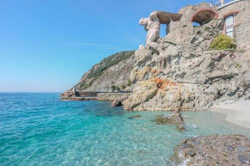 蒙特罗索阿尔马雷Villa degli Argentieri的海旁悬崖上的一个人的雕像