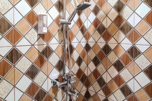 占碑市RedDoorz Syariah near Telanaipura Jambi的浴室拥有棕色和白色的瓷砖墙壁