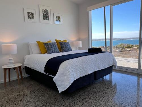Vivonne BayWild Retreat - Luxury Home with Magnificent Views的一间卧室设有一张床,享有海景