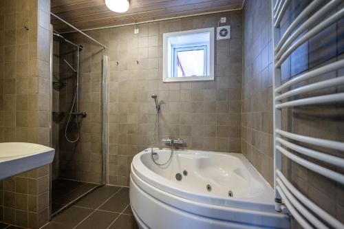 伊卢利萨特4-bedroom house with sea view and hot tub的带浴缸、卫生间和窗户的浴室