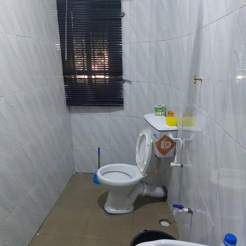 伊巴丹Diek Guest House的一间带白色卫生间的浴室和窗户。