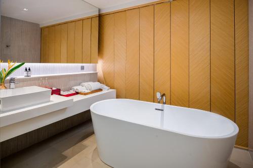 蔻立Ramada Resort by Wyndham Khao Lak的浴室配有白色浴缸和水槽