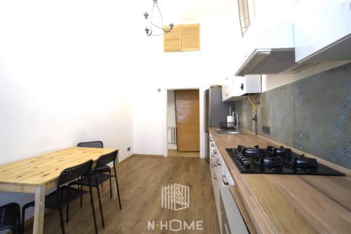 罗兹Apartament z kominkiem的厨房配有炉灶和桌椅