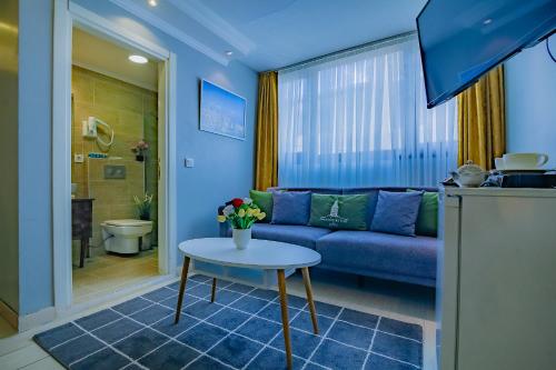 伊斯坦布尔Galataport Flat Company的客厅配有蓝色的沙发和桌子