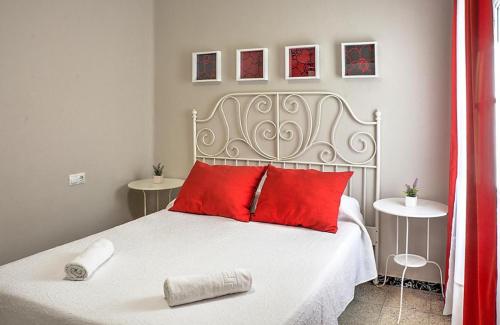 塞维利亚Ritual Sevilla, piedra preciosa的卧室配有带红色枕头的白色床