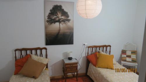 Casa Rural, paz y naturaleza.的卧室配有两张床,墙上挂着一幅画