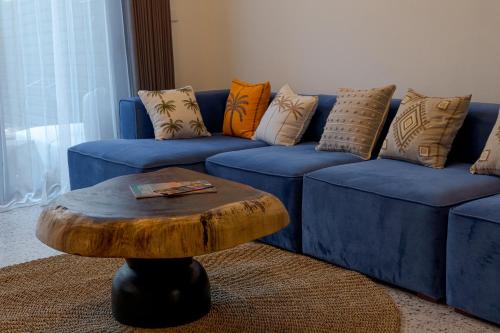 坎古Sunny Village Batu Bolong的蓝色沙发、枕头和木制咖啡桌