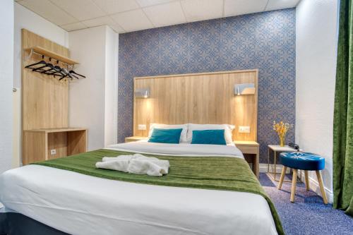 梅斯Hôtel Escurial - Centre Gare的一间卧室设有一张大床和蓝色的墙壁