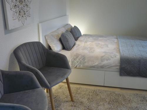 洛布Bungalow Oase der Ruhe的一间卧室配有一张床、一把椅子和一把椅子