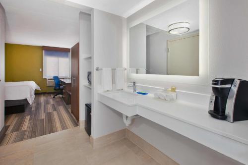 费尔法克斯费尔法克斯阿灵顿大道快捷假日酒店的白色的浴室设有水槽和镜子