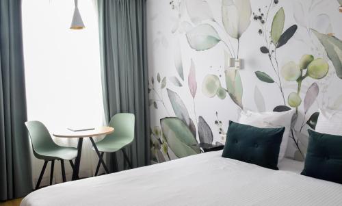 海牙原住酒店的酒店客房带一张床、一张桌子和椅子