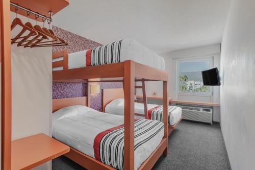 图斯特拉古铁雷斯City Express Junior by Marriott Tuxtla Gutierrez Poliforum的配有电视的客房内的两张双层床