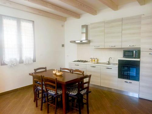阿雷内拉Villa La Sosta - 150m dal mare - Patio Privato e Areal Relax的厨房配有木桌、椅子和水槽