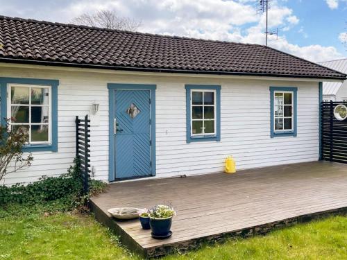 阿里尔德7 person holiday home in ARILD的一座小房子,甲板上设有一扇蓝色的门
