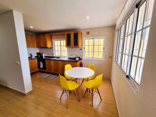 阿科达卡列塔Casa Torbit, Apartment in Arco da Calheta的厨房配有桌子和黄色椅子