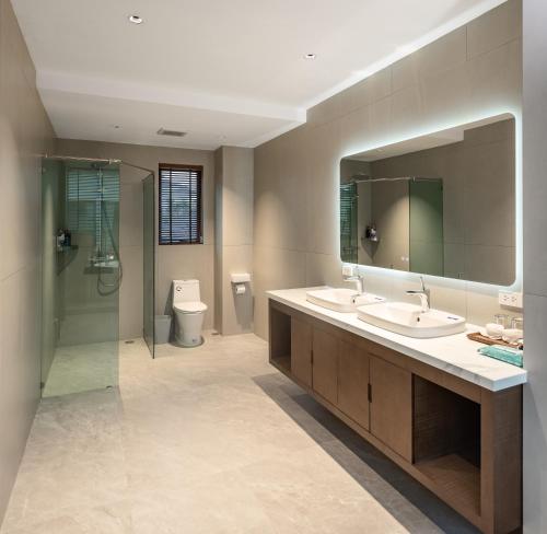 乔木提恩海滩圣地亚哥别墅度假酒店的浴室设有2个盥洗盆、淋浴和镜子。