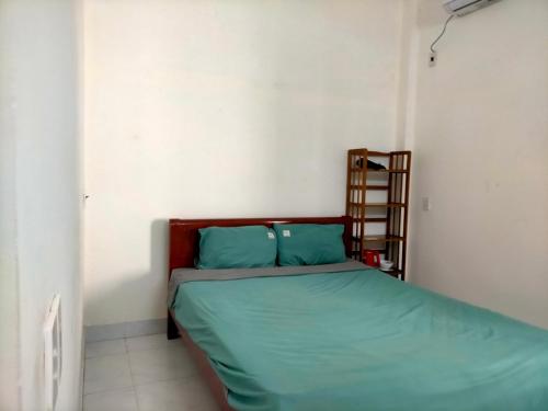 岘港TN's House的一间小卧室,配有一张带绿色床单的床