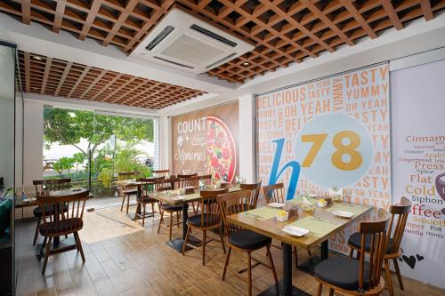 胡鲁马累h78 veli的餐厅设有木桌和椅子,墙上有标志