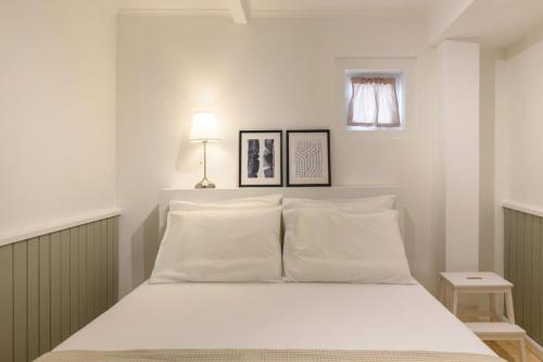 科孚镇Keramidogatos Manos Guest House, Corfu Old Town的卧室配有白色的床和2个枕头