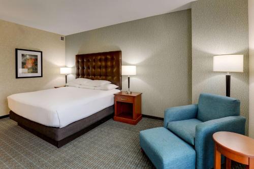 钱德勒德鲁里凤凰城钱德勒时尚中心套房酒店的配有一张床和一把椅子的酒店客房