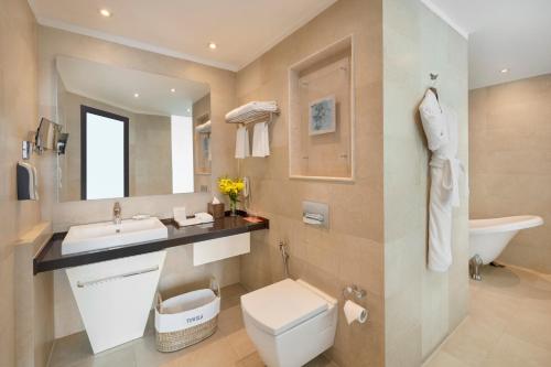 新德里Welcomhotel by ITC Hotels, Dwarka, New Delhi的一间带卫生间、水槽和镜子的浴室