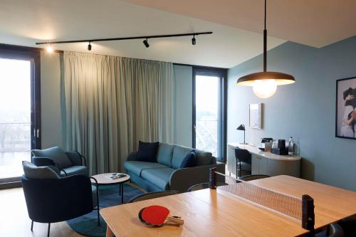 美因河畔法兰克福Scandic Frankfurt Hafenpark的客厅配有沙发、椅子和桌子