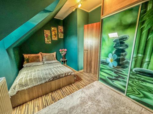 VeszprémfajszSpa Residence Családi Wellness Apartman的一间卧室设有一张床和绿色的墙壁