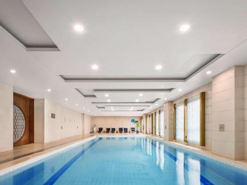 沈阳沈阳瑞士酒店的一座带泳池导览器的大楼内的大型游泳池