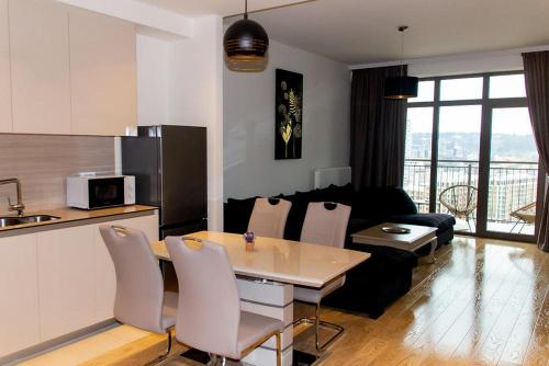 贝尔格莱德BW Aurora Lux Panorama的厨房以及带桌子和沙发的客厅。