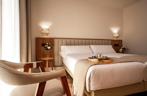 托莱多Hotel Cigarral Santa María的配有一张床和一把椅子的酒店客房