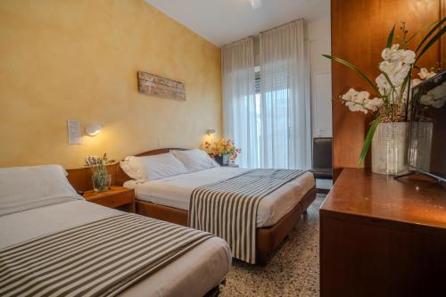 里米尼Hotel Mia的酒店客房设有两张床和窗户。