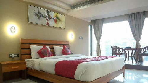 古瓦哈提HOTEL APOLLO GRAND A UNIT OF SATYAM ASSOCIATES的一间卧室设有一张床和一个大窗户