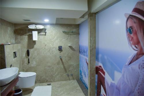 古瓦哈提HOTEL APOLLO GRAND A UNIT OF SATYAM ASSOCIATES的站在带水槽的浴室中的女人
