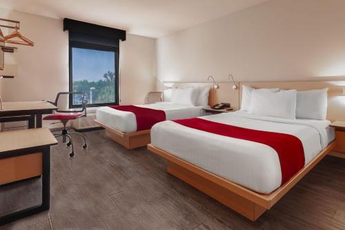 莱昂莱昂城市快捷酒店的酒店客房配有两张床和一张书桌