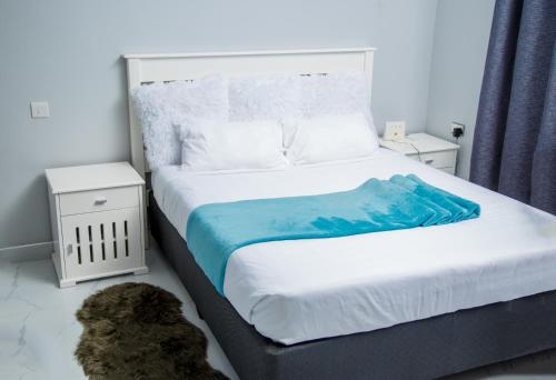奇帕塔Modern Village Apartments的一间卧室配有一张大床,上面有蓝色的毯子