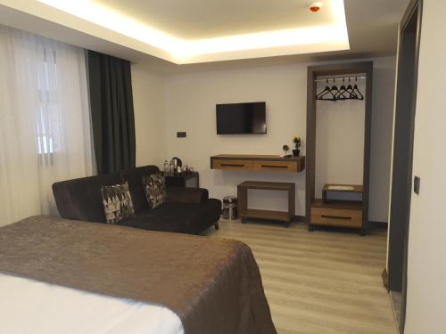 安塔利亚Hotel Kriti的酒店客房配有床、沙发和电视。