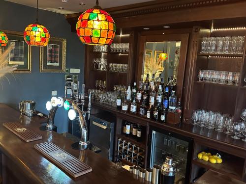 伯福德Burford Lodge Hotel - Adults only的酒吧提供酒瓶和照明