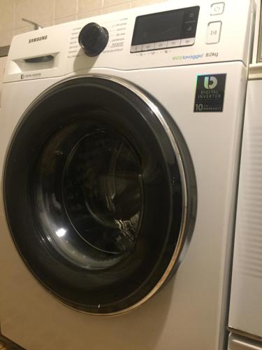 诺瓦拉Bellini Apartment's的配有黑色门的白色洗衣机