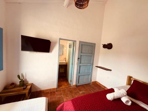巴里查拉Casa Quintanilla Barichara的卧室配有一张床,墙上配有电视